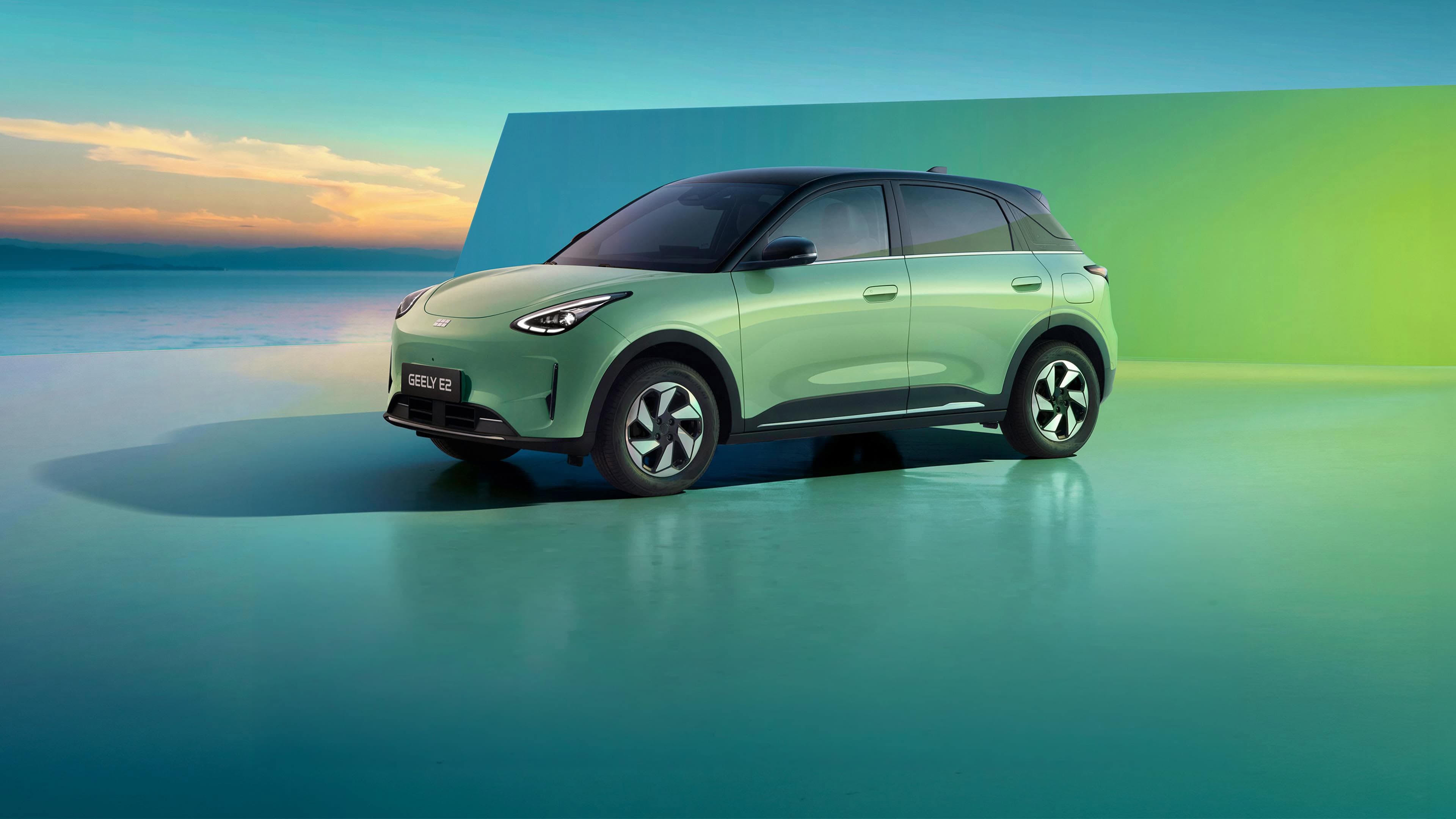 Geely E2 en un entorno de estudio junto al mar, al atardecer